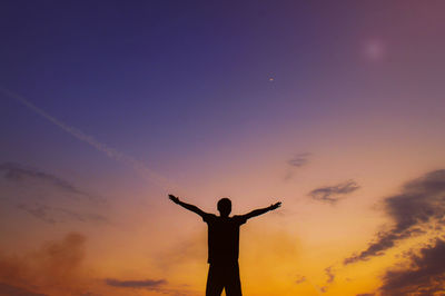 Rear view of silhouette man standing against sky during sunset