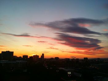 Silhouette buildings against sky during sunset