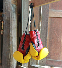 Close-up of shoes hanging on rope against wall