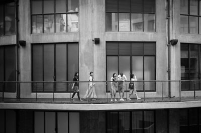 People walking on glass window of building