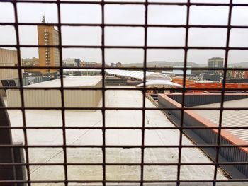 View of swimming pool against buildings seen through window