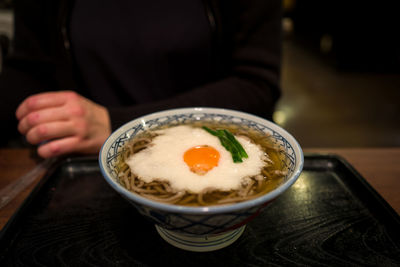 High angle view of noodles served with egg in bowl on table at home