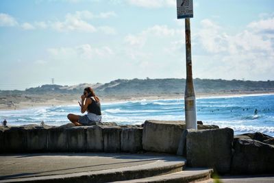 Rear view of woman sitting on bench