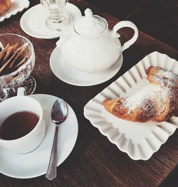 High angle view of croissant and coffee on breakfast table