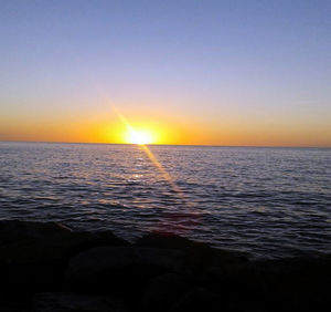 Scenic view of sea against clear sky during sunset