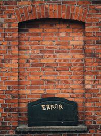 Error sign on shelf against brick wall