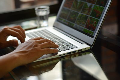 Close-up of woman using laptop on table