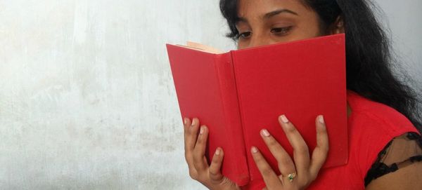 Close-up of woman with hands against white background