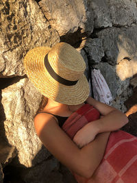 Low section of woman sitting on rock