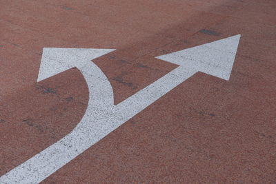 High angle view of arrow sign on road in city