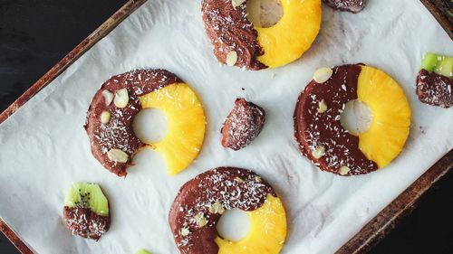 High angle view of chocolate coated pineapple slices in plate