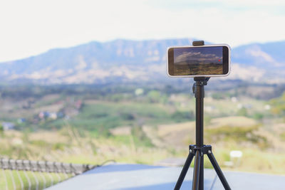 Close-up of security camera against sky