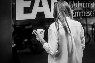 Rear view of woman holding text