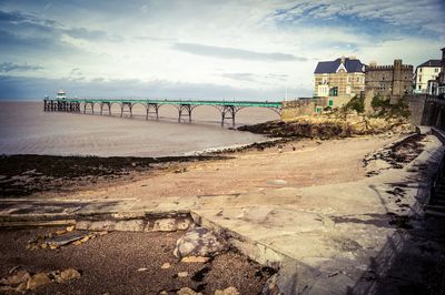 Bridge over sea and buildings against sky