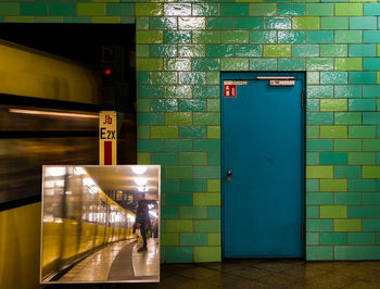 Reflection of man standing in subway station against closed door