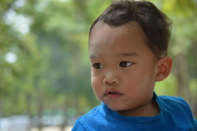 Portrait of cute boy looking away outdoors