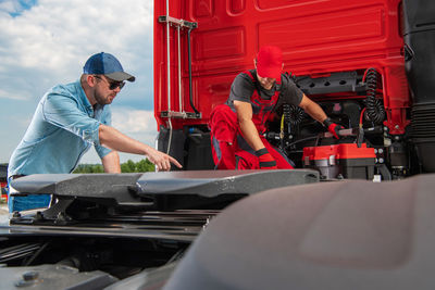 Side view of man repairing car