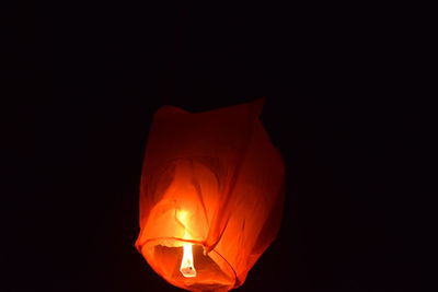 Illuminated lantern over black background