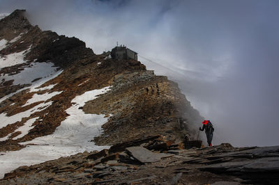 Hiker standing on mountain during foggy weather