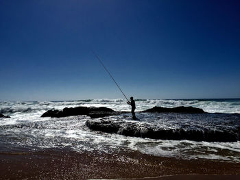 Atlantic wave shore fisherman 