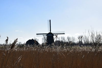 Traditional windmill on field against sky