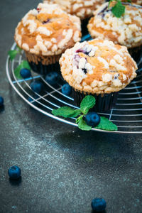 High angle view of cupcakes and fruits on cooling rack