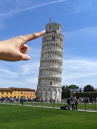 Optical illusion of finger pushing the leaning tower of pisa. 