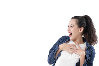 Smiling young woman looking away against white background