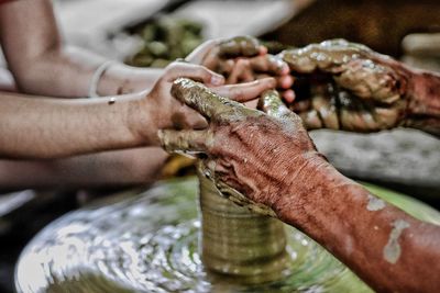 Cropped hands making pots