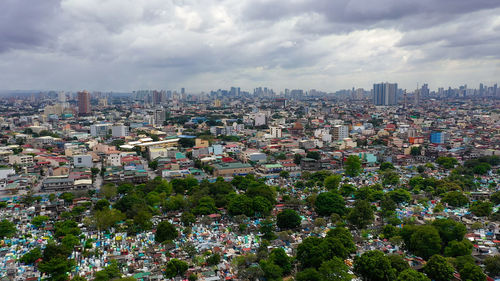 Manila north cemetery on the background of skyscrapers and modern buildings, aerial drone. 