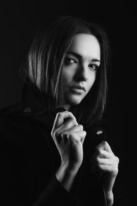 Close-up portrait of woman against black background