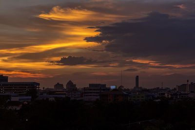 View of cityscape against cloudy sky during sunset