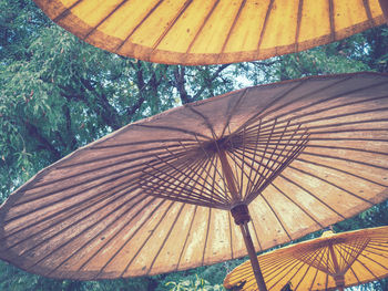 Low angle view of parasol against trees