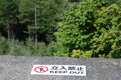 High angle view of warning sign against trees