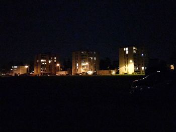 Illuminated cityscape against sky at night