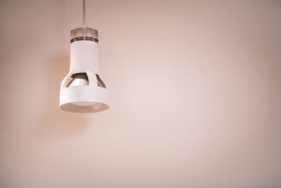 Illuminated light bulb hanging from ceiling