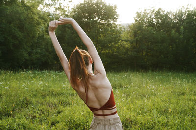 Rear view of young woman exercising at park