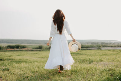 Woman with umbrella walking on field