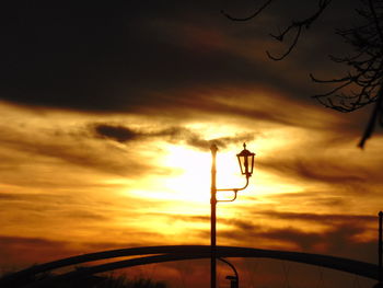 Low angle view of street light against cloudy sky