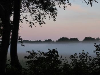 Scenic view of lake against sky at sunset