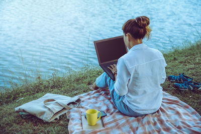 Rear view of woman sitting at beach