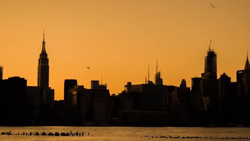 Silhouette of buildings in city during sunset