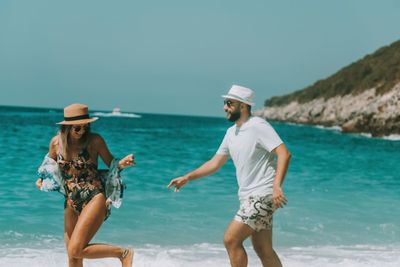 Woman enjoying at beach against sky