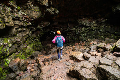 Rear view of woman walking on rocks