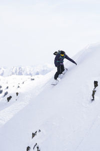 Mature man snowboarding on pyrenees mountain slope, catalonia, spain