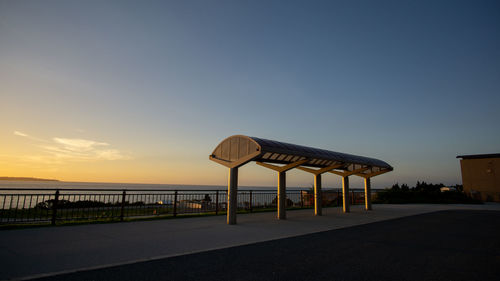 Lifeguard hut on road by sea against clear sky