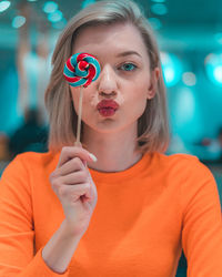 Portrait of woman holding lollipop