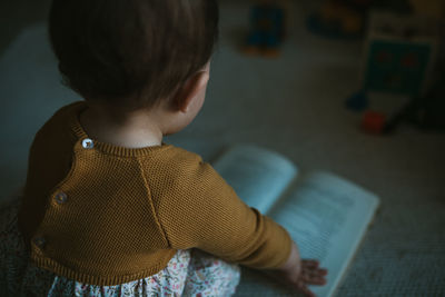 Close-up of girl reading book at home