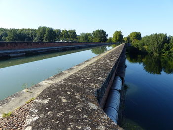 Scenic view of dam on lake against sky