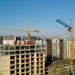 Construction site by buildings against clear sky